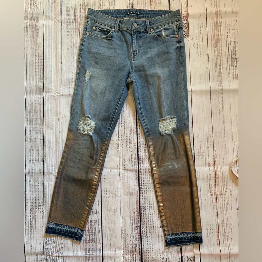 Level 99 jeans. Gold/silver design on bottom. Mid rise. Size 27.